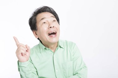 Beyaz arka planda parmağı olan yaşlı Asyalı bir adamın portresi.