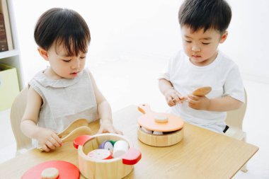 Evde oyuncaklarla oynayan sevimli Japon çocukları.