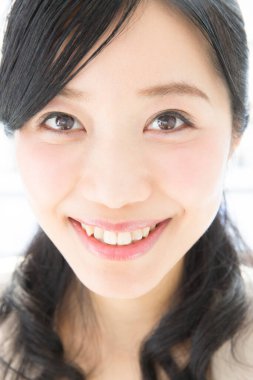 Gülümseyen genç bir kadın, bulanık arka planda soyutlanmış.