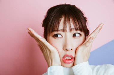 Yüzünde elleri olan Asyalı kadın. 