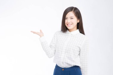 Güzel Japon kadının beyaz arka planda bir şeyler gösterdiği bir stüdyo fotoğrafı. 