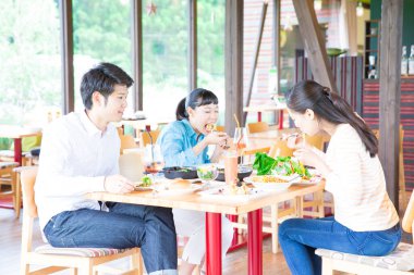 Asyalı arkadaşlar restoranda yemek yiyorlar. 