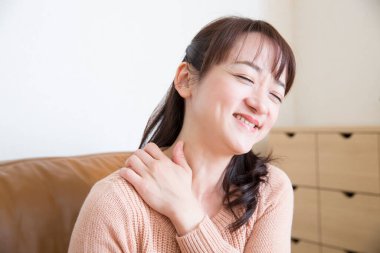 Evde boynu ağrıyan genç bir kadın.