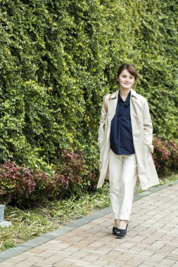 Genç bir kadın parkta yürüyor. 