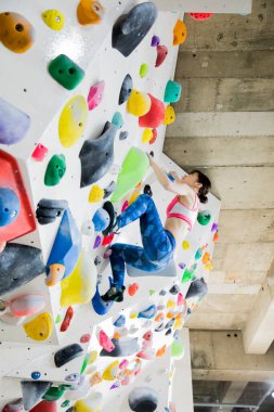 Güzel Japon kadın spor salonunda duvara tırmanıyor. 