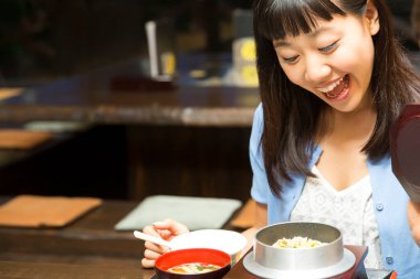 Restoranda geleneksel Japon yemeklerini seven bir kadın.