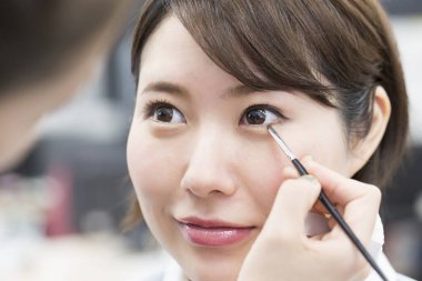 Kadın göz makyajı yaptırıyor.