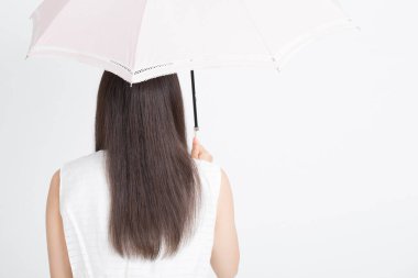 Beyaz arka planda şemsiyesi olan güzel bir kadın. 