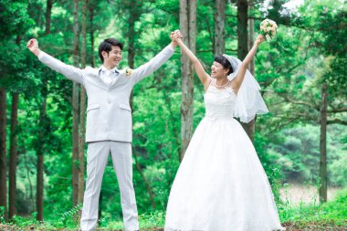 Mutlu Asyalı gelin ve damat parkta 