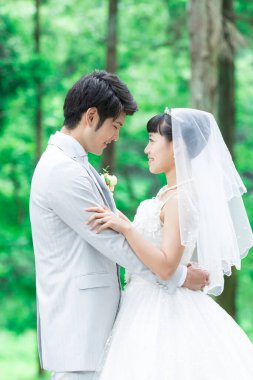 Parkta poz veren Asyalı gelin ve damat 