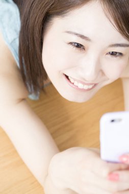 Evde akıllı telefon kullanan bir kadın. 