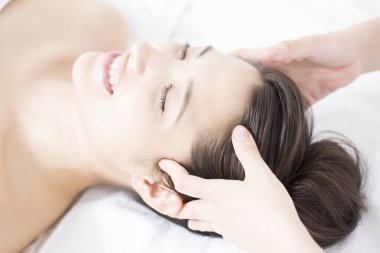 Genç ve güzel Japon kadın spa merkezinde yüz masajından zevk alıyor..