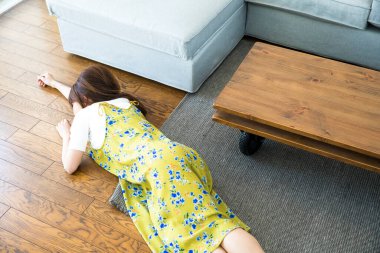 Kanepeden düşen Asyalı genç kadın. 