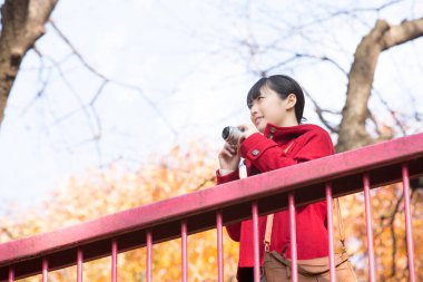 Parkta kamerası olan bir kadın.