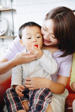 Asyalı aile, oğul ve anne evde yemek yiyor. 