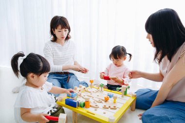 Asyalı anne ve kızları birlikte vakit geçiriyorlar. 