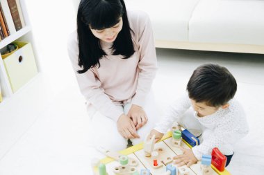 Evde annesiyle oynayan tatlı Japon çocuk.