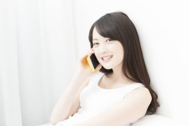 Evde cep telefonu kullanan bir kadın