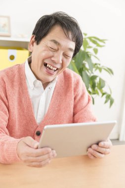 Gülümseyen kıdemli adam tablet kullanma