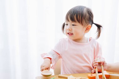 Ev içi oyuncaklarla oynayan sevimli Japon kızın yakın çekimi. 