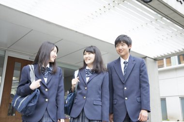 Çantalı gülümseyen Japon öğrencilerin portresi. 