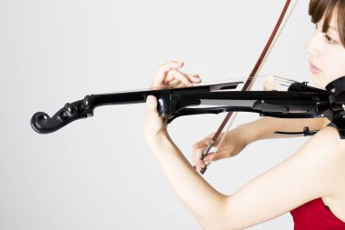 Güzel Asyalı kadın kemanla poz veriyor, yaklaşın.