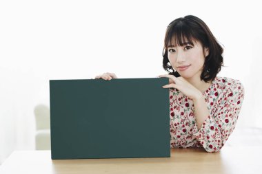 Boş tahtası olan Asyalı kadın