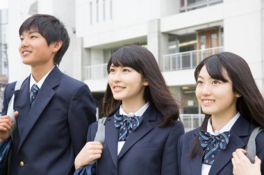 Okulda çantalı genç Japon öğrencilerin portresi.
