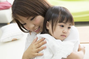 Anne ve kızı evde sarılıyorlar.