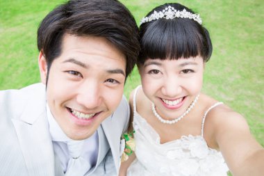 Asyalı gelin ve damat selfie çekiyor. 