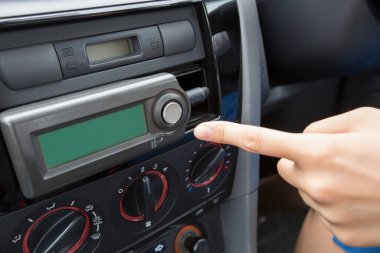 Arabanın içi. Bir adamın elini arabanın torpidosuna doğru yaklaştırın.