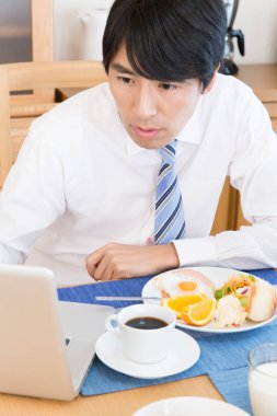 businessman having breakfast in the morning and using laptop
