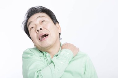  Beyaz arka planda sırt ağrısı çeken yaşlı bir Asyalı..