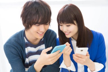 Genç çift cep telefonu kullanıyor, oyun oynuyor. 