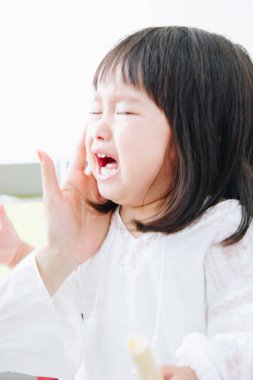 Asyalı anne ve kızı evde ağlıyorlar. 