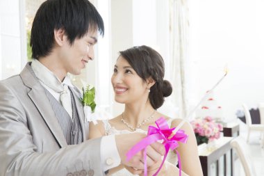 Güzel, mutlu, genç bir çift yanan mumu birlikte tutuyorlar.   