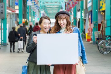 İki Asyalı kadın ve boş kart sokağı.