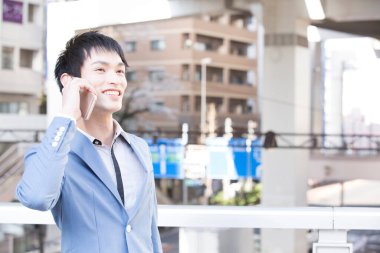 Şehirde cep telefonuyla konuşan genç işadamının portresi