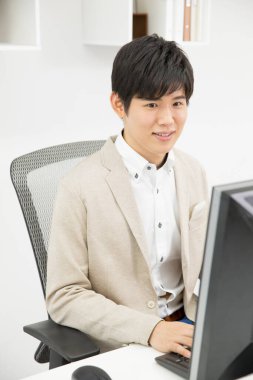 Genç işadamı ofiste çalışıyor.