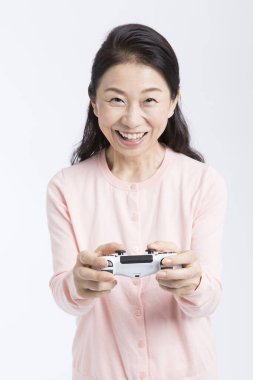 Beyaz arka planda video oyunu denetleyicisini kullanan kadın