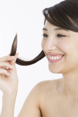  Japon kadın uzun saçlarını tutuyor ve saçlarını ayırıyor. 