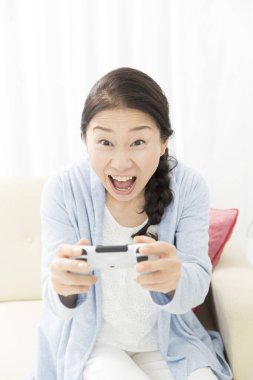 Video oyunu oynayan genç Asyalı kadın