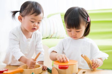 İki sevimli Asyalı kız evde oynuyorlar.