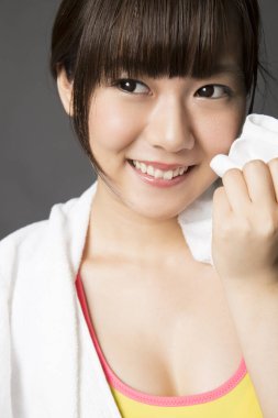 Antrenmandan sonra havlusu olan genç bir kadın.