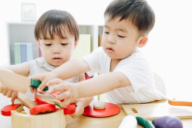 Evde oyuncaklarla oynayan sevimli Japon çocukları.