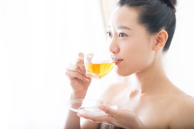 Evde çay içen genç Asyalı kadın portresi.