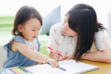Annesiyle resim çizen tatlı Asyalı kız.