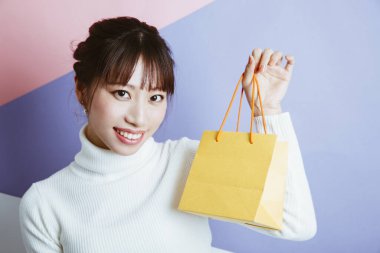 Alışveriş çantalı genç bir kadın, stüdyo fotoğrafı. 