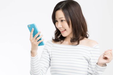 Beyaz arka planda akıllı telefonu olan güzel bir Japon kadının stüdyo fotoğrafı. 