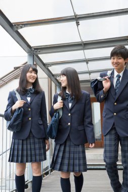 Okulda çantalı genç Japon öğrencilerin portresi.